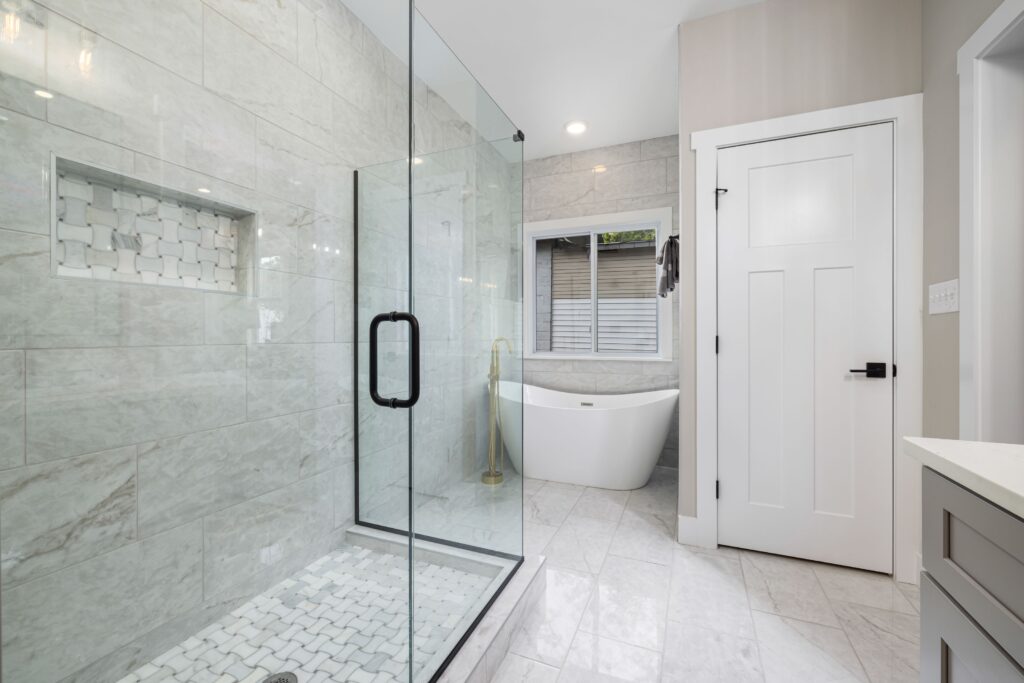 Newly added full bathroom with a glass shower enclosure, freestanding tub and tiled floor