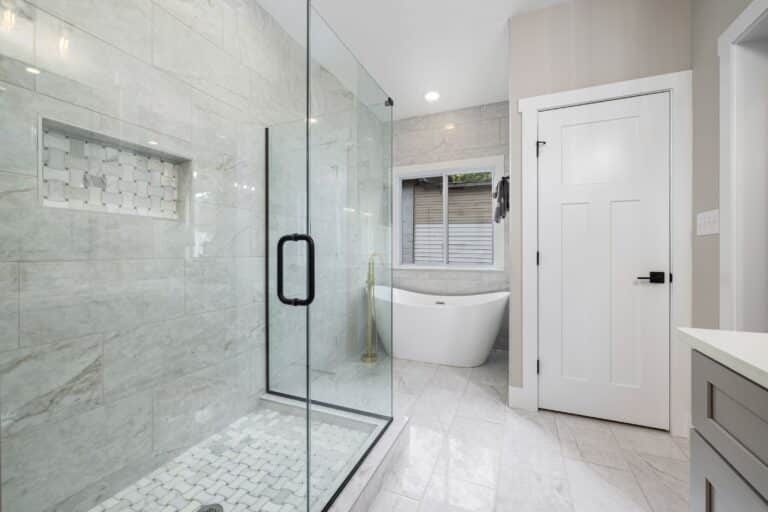 Newly added full bathroom with a glass shower enclosure, freestanding tub and tiled floor
