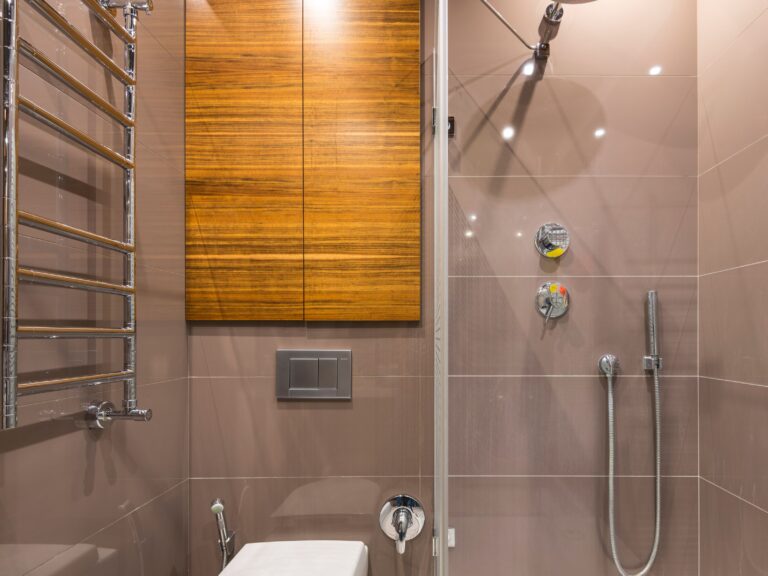 Replacement shower with a glass enclosure, tiled walls and chrome fixtures beside a wood vanity