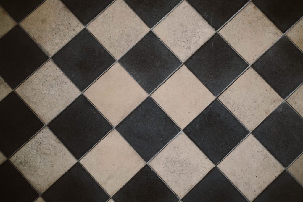 Bathroom floor tiled in a diagonal black and cream checkerboard layout with even grout joints