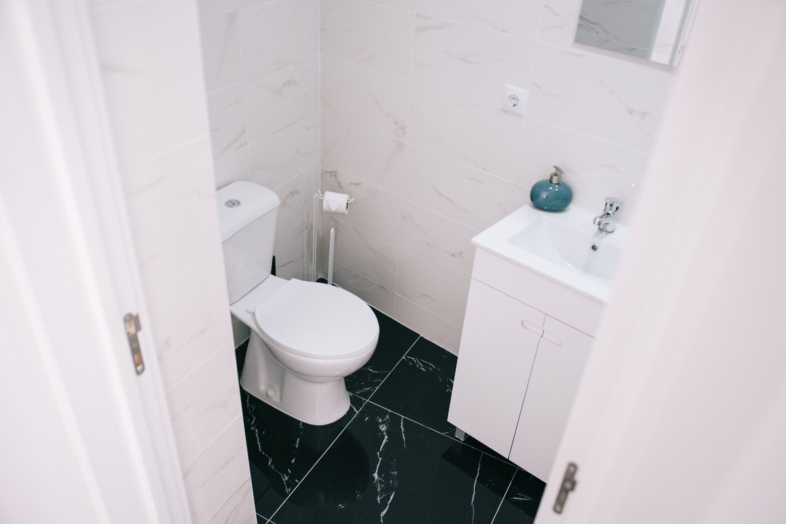 Renovated bathroom with dark marble-look floor tile in Holmdel NJ by DK PRO Construction