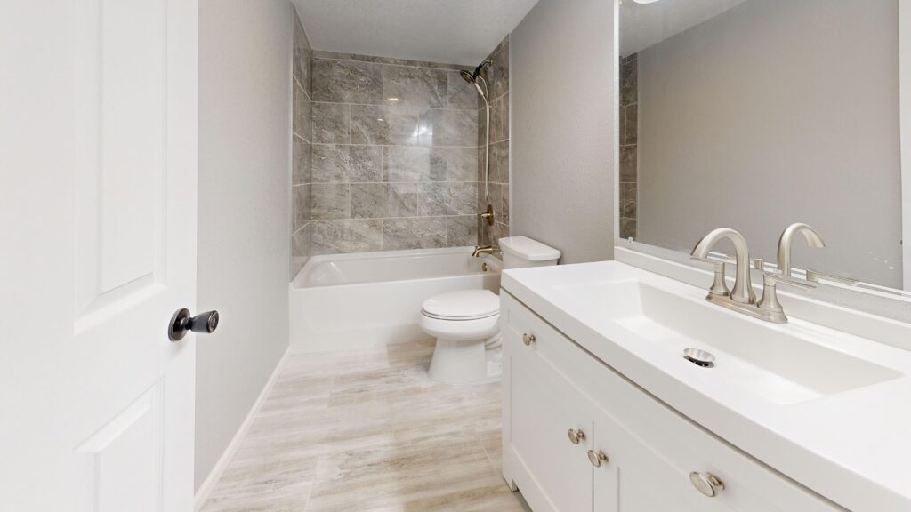 Standard-size full bathroom with a tub and shower along one wall and a vanity opposite