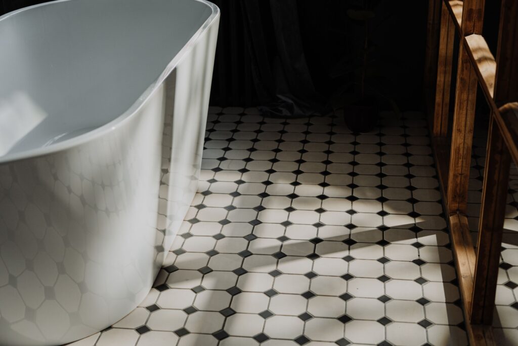 Existing black and white patterned tile floor in a bathroom with a freestanding tub