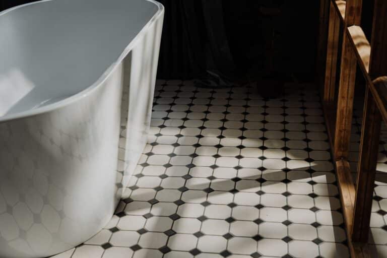 Existing black and white patterned tile floor in a bathroom with a freestanding tub